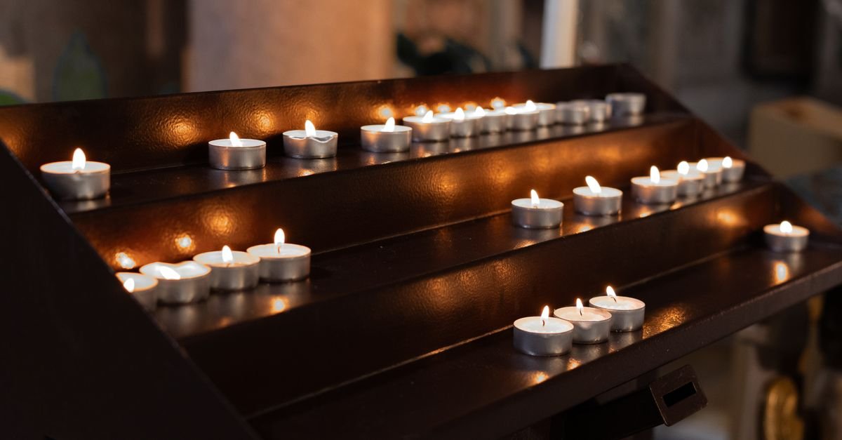 Velas acesas em um suporte dentro de uma igreja