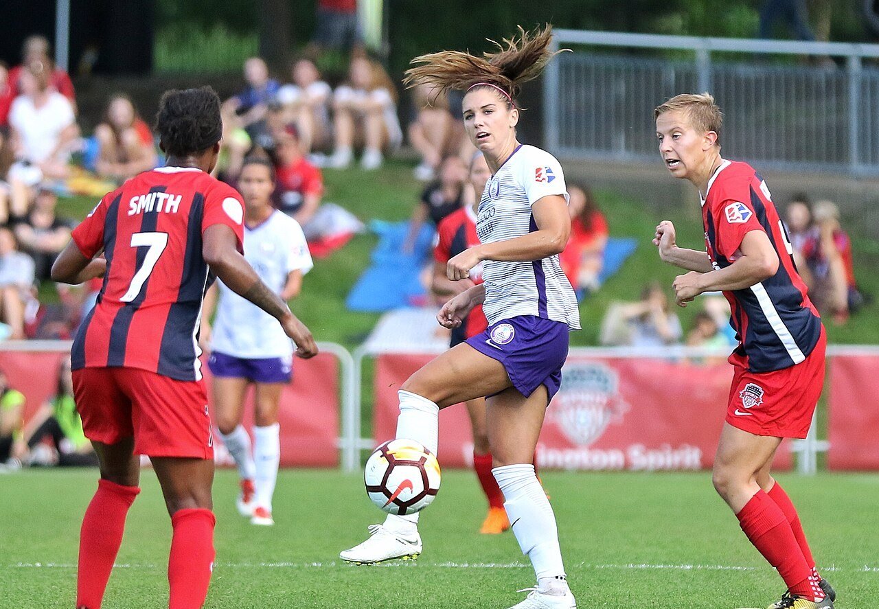 Atacante Alex Morgan domina a bola durante partida de futebol feminino