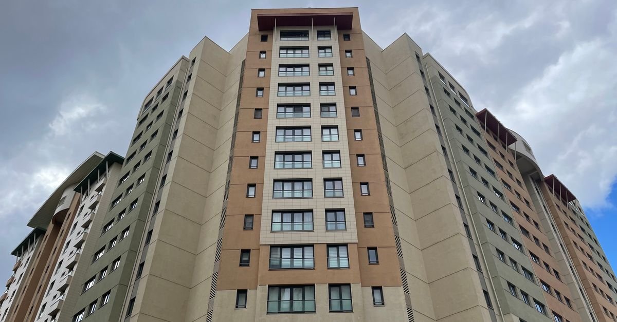 Fachada de prédio residencial de apartamentos vista de baixo, com céu nublado ao fundo