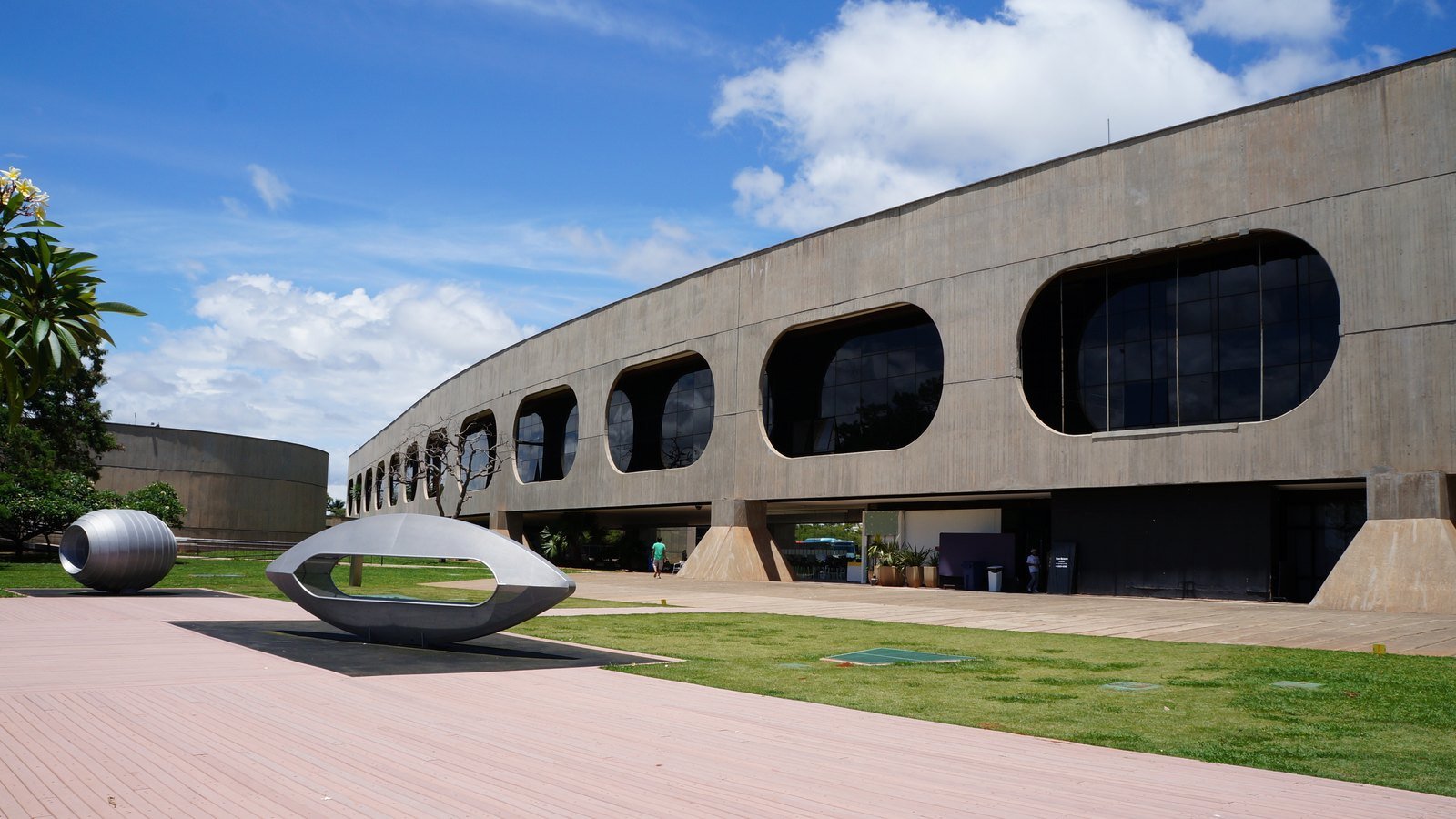 Prédio do CCBB Brasília, de concreto com janelas ovais, e escultura no gramado; foto de arquivo