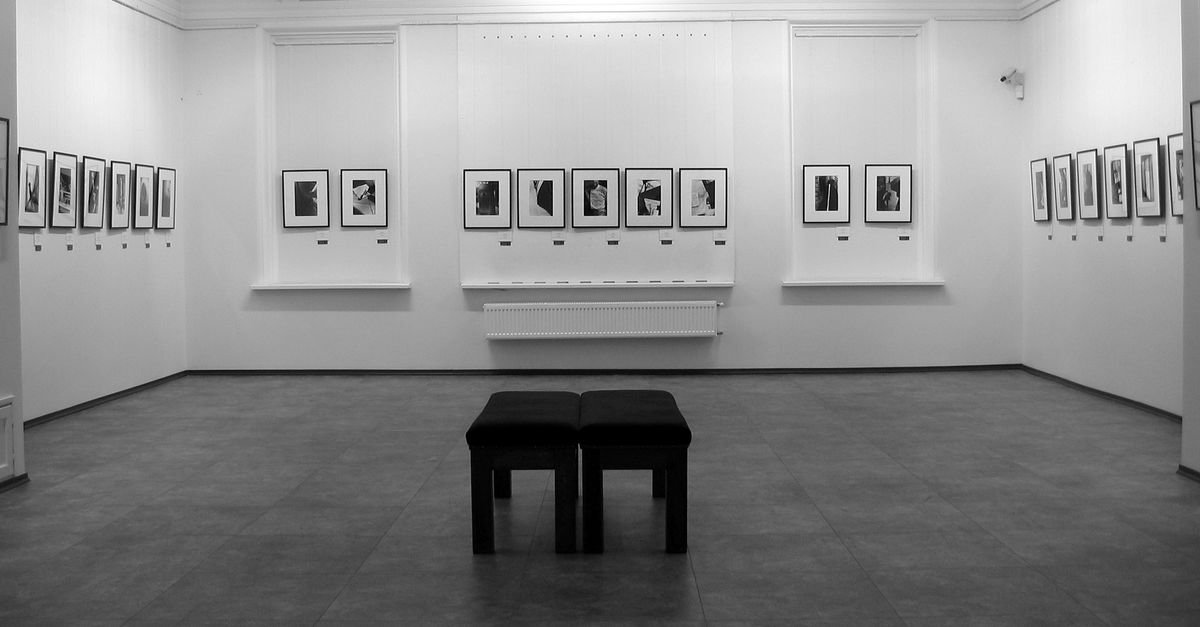 Sala de exposição com paredes brancas e fotografias emolduradas em preto e branco