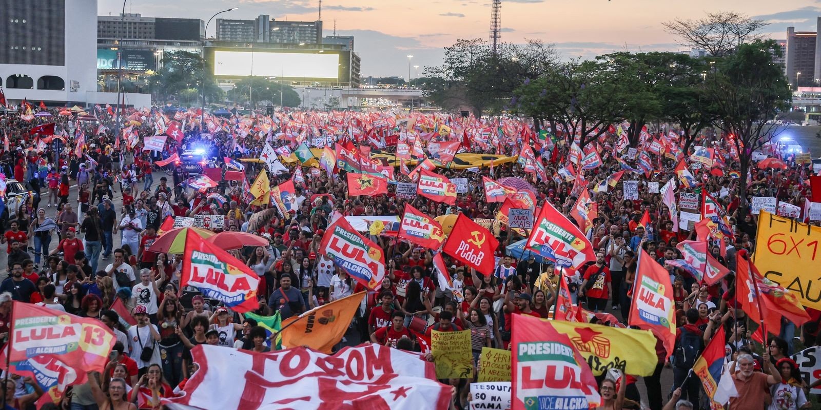 Multidão com bandeiras de Lula e cartazes caminha pela Esplanada dos Ministérios, em Brasília, no fim da tarde
