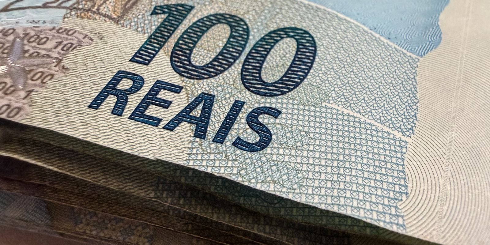 Close de cédulas de 100 reais empilhadas