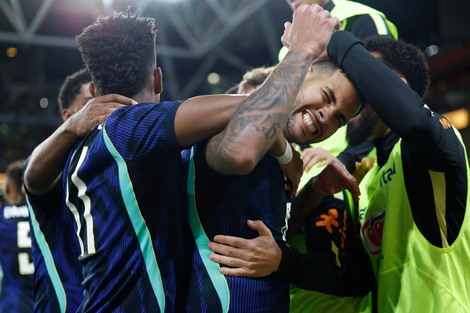 Jogadores da selecao brasileira de uniforme azul se abracam para comemorar gol no estadio de Brisbane