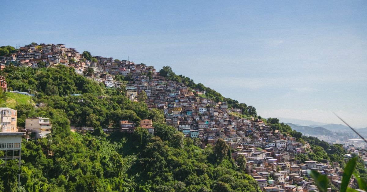 Vista aérea de favela em encosta de morro cercada por vegetação no Rio de Janeiro