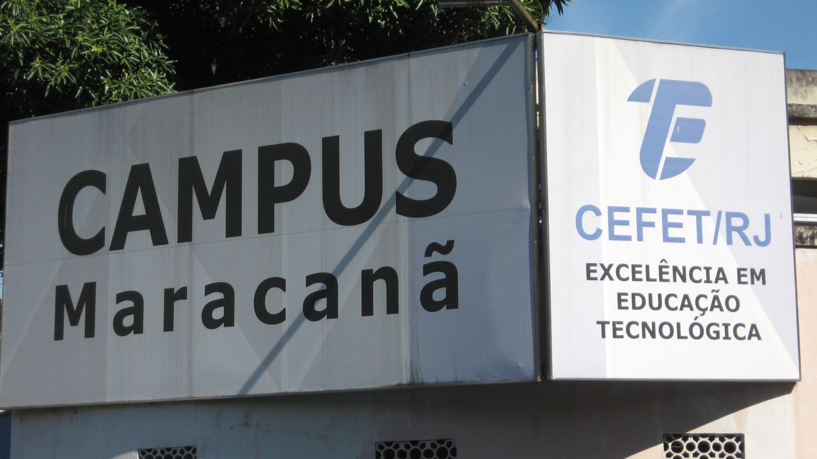 Placa na entrada do campus Maracanã com o nome CEFET/RJ e a frase Excelência em Educação Tecnológica