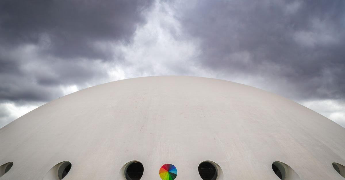Cúpula branca sob céu carregado de nuvens, imagem ilustrativa