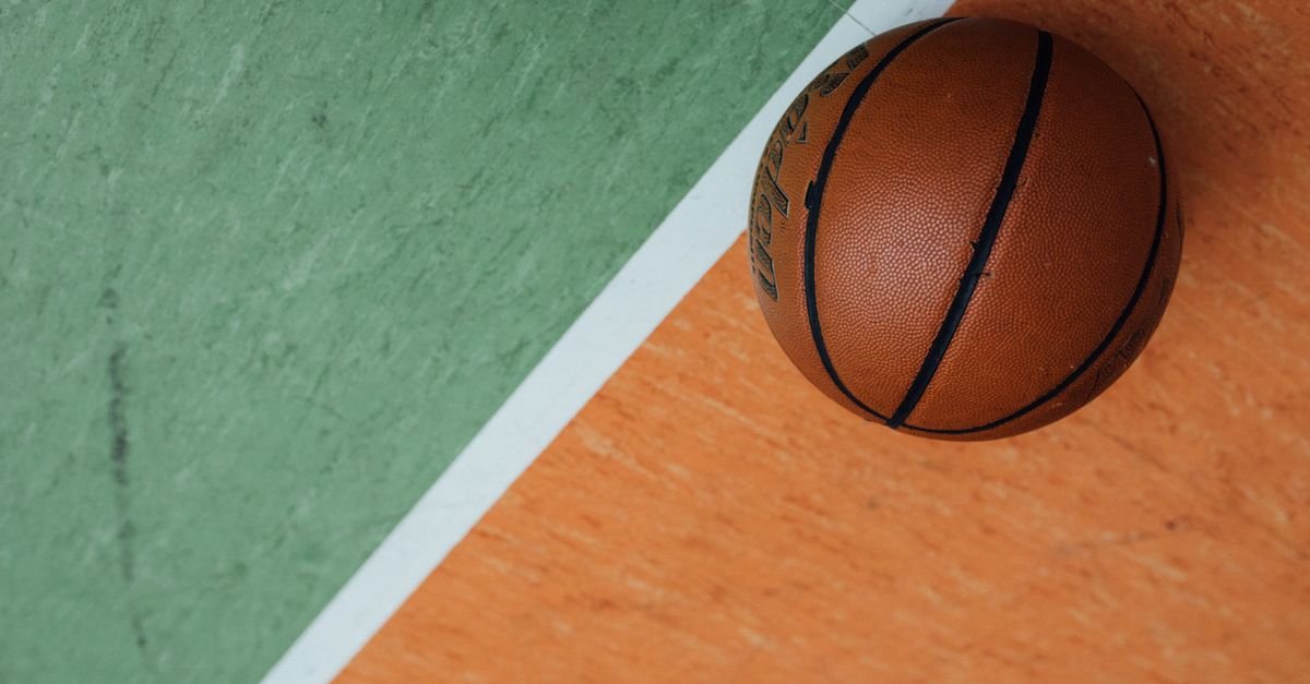 Bola de basquete sobre quadra nas cores verde e laranja