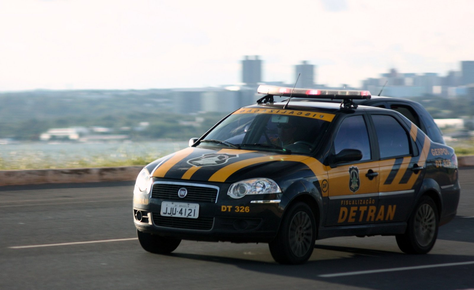 Viatura da fiscalização do Detran-DF em movimento, com a silhueta de Brasília ao fundo (foto de arquivo de 2011)