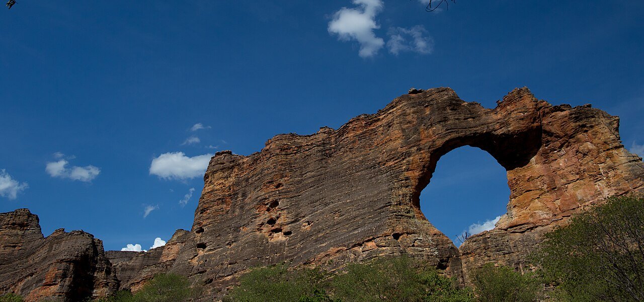 Formacao rochosa do Parque Nacional da Serra da Capivara, no Piaui, com arco de pedra sob ceu azul