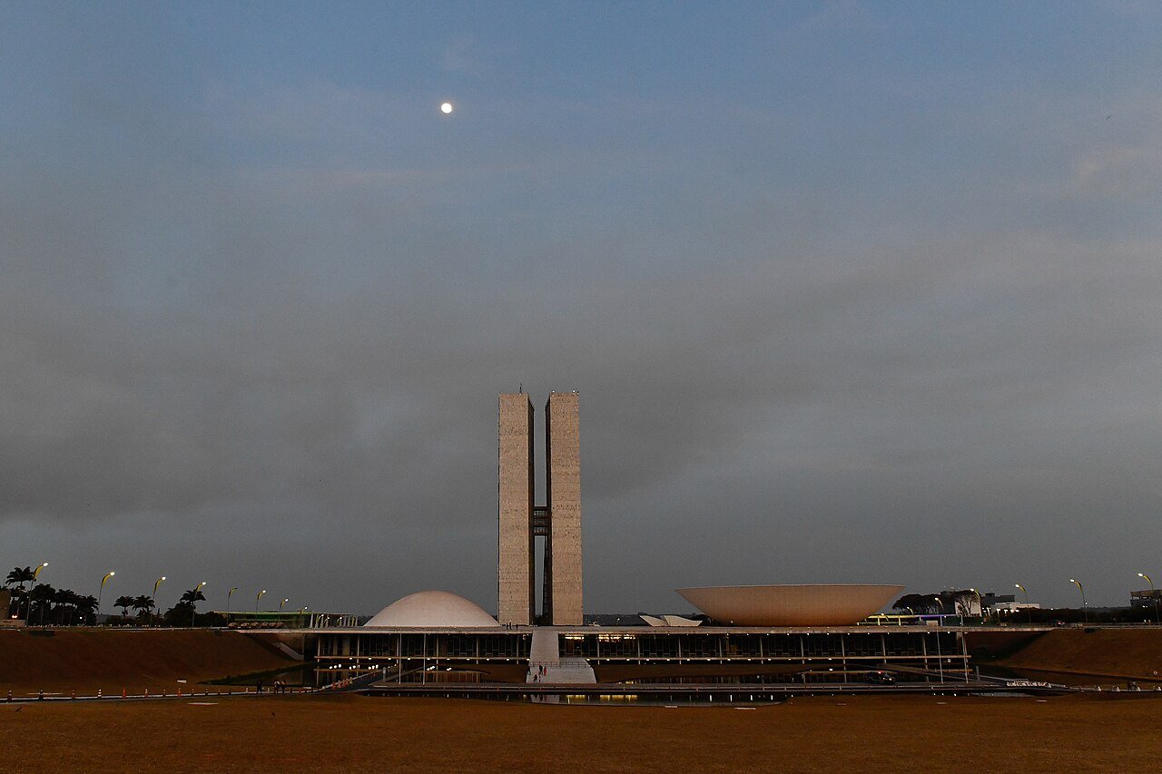 Fachada do Palácio do Congresso Nacional ao entardecer, com as cúpulas e as torres gêmeas