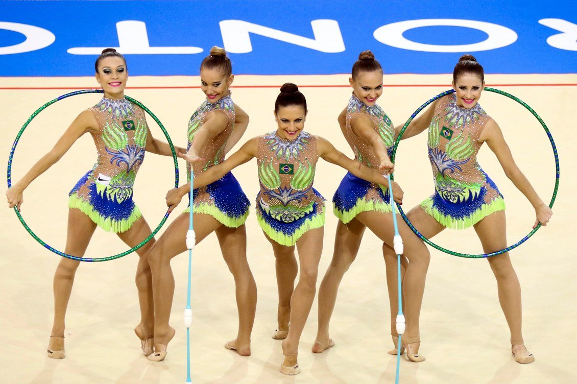Conjunto brasileiro de ginástica rítmica em apresentação com arcos e maças