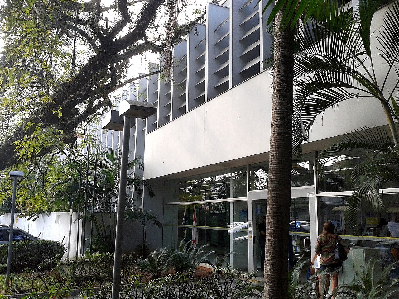 Fachada de agência do Banco do Brasil vista da calçada, com entrada de vidro