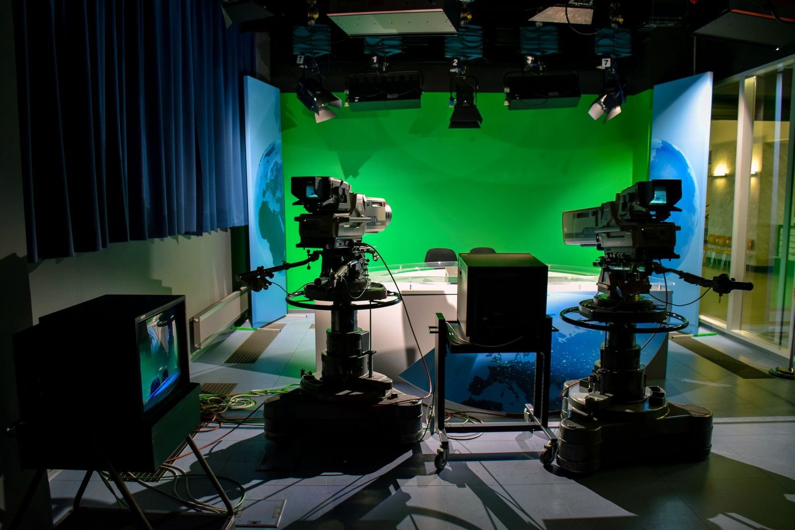 Estúdio de TV com duas câmeras e cenário de fundo verde