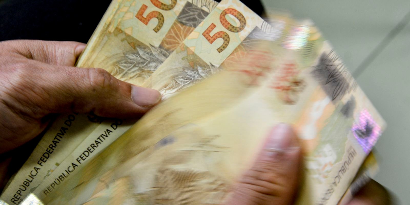 Mãos contando notas de R$ 50; foto de arquivo da Agência Brasil