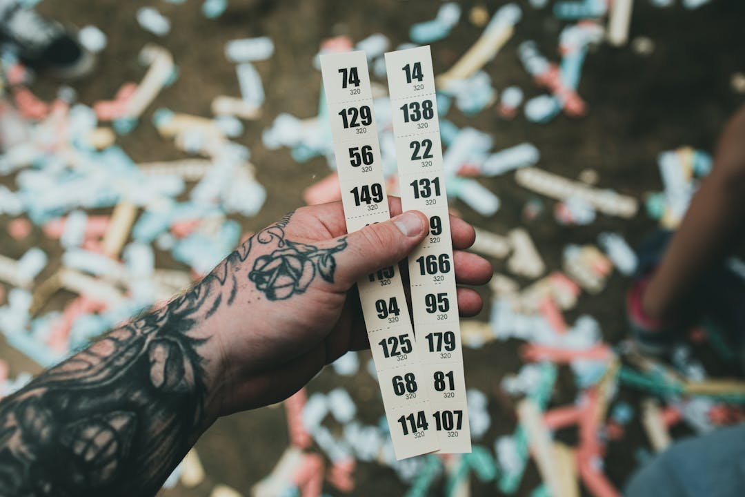 Bilhetes de rifa numerados em mao com confete ao fundo
