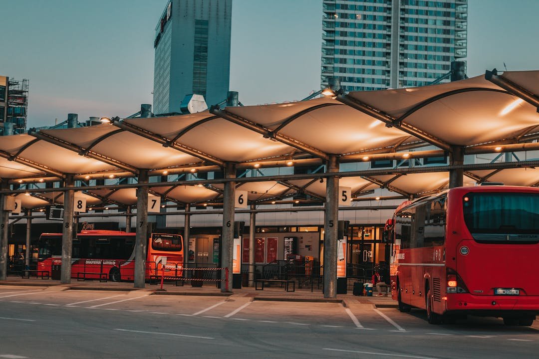 Estacao com varios onibus parados em plataformas numeradas no fim de tarde