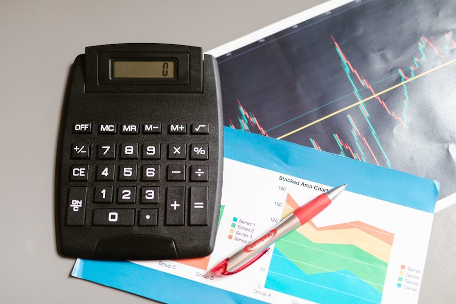 Calculadora e caneta sobre relatórios financeiros com gráficos