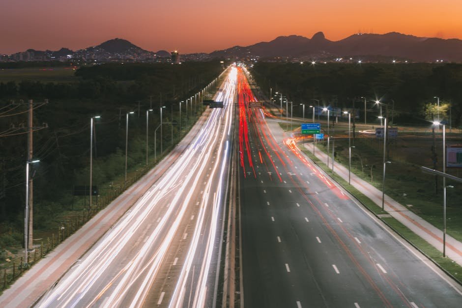 Vista aérea de rodovia com luzes de veículos ao entardecer