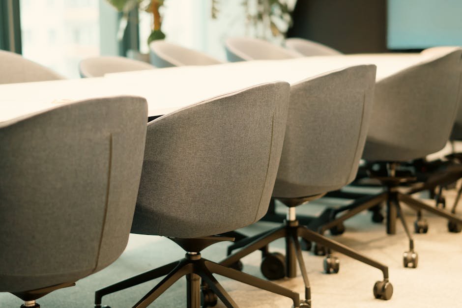Sala de reuniões moderna com cadeiras cinza enfileiradas