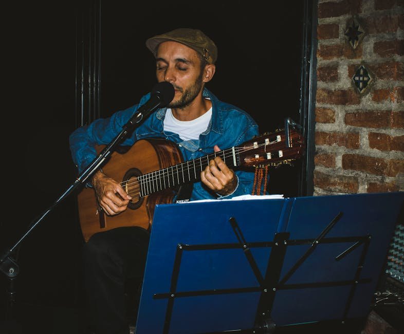 Músico tocando violão e cantando ao microfone em apresentação