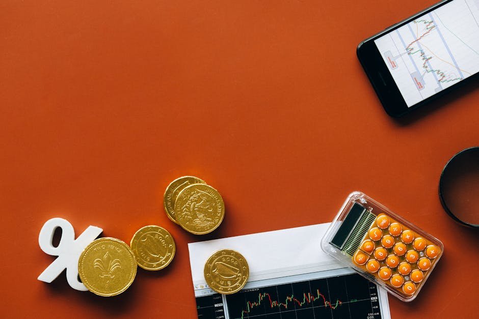 Moedas douradas, calculadora e gráficos financeiros sobre fundo laranja