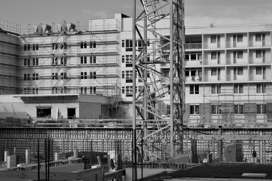 Prédio em construção com andaimes e guindastes em vista monocromática