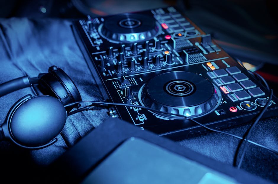Mesa de DJ com controladora e fones de ouvido sob luz azul