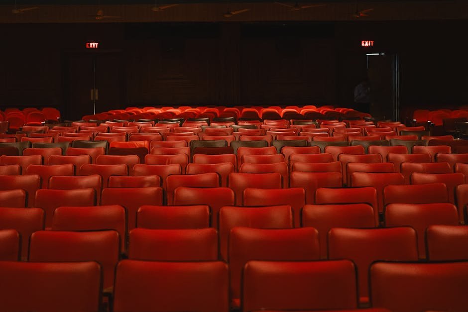 Sala de cinema com poltronas vermelhas vazias