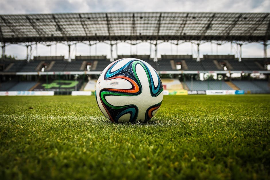 Bola de futebol em campo de grama verde