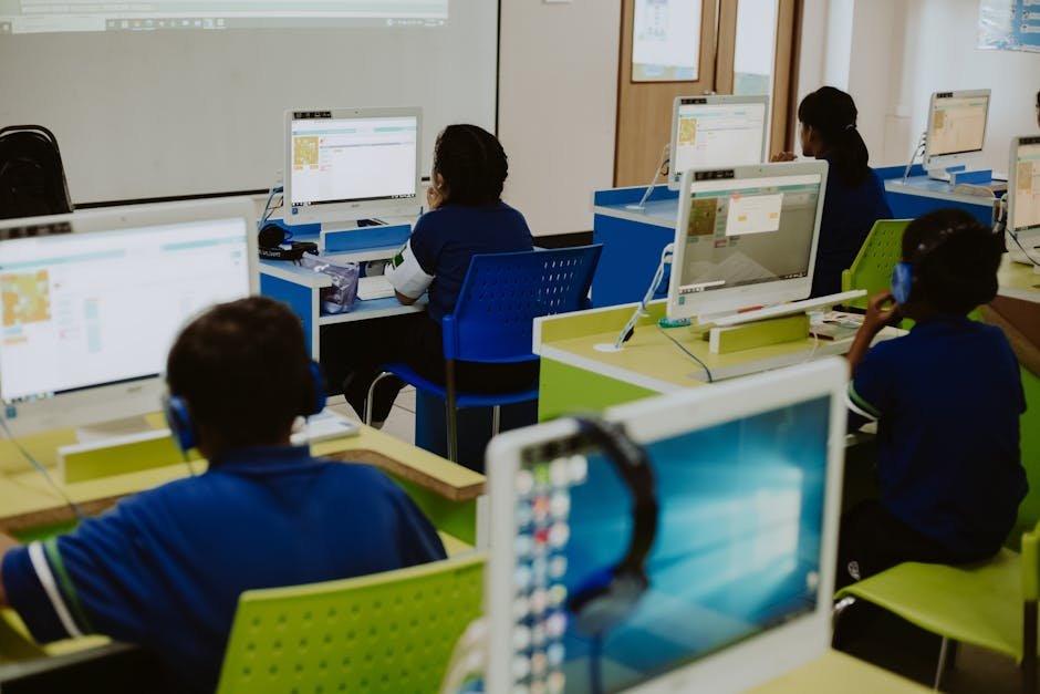 Sala de aula com computadores e estudantes programando