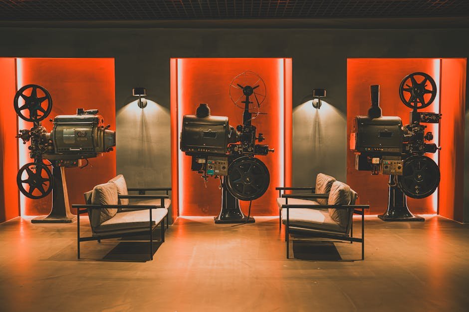 Sala de cinema iluminada com cortinas vermelhas e projetor