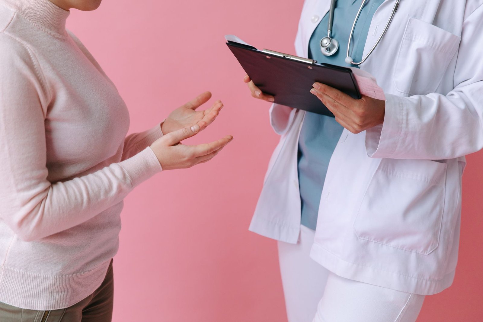 Paciente conversa com médica que segura prancheta durante consulta