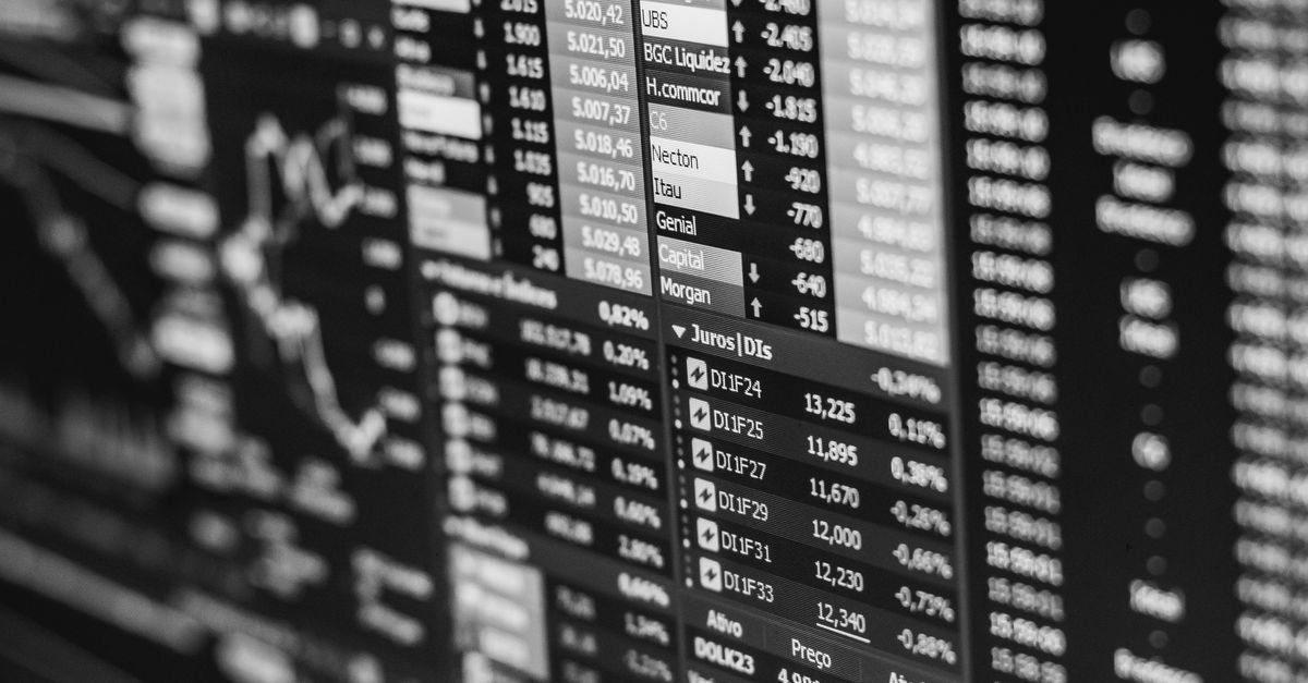 Painel de cotações do mercado financeiro brasileiro em preto e branco, com taxas de juros e ativos