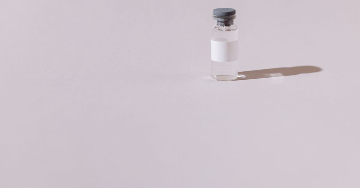 Frasco de vidro de medicamento com rotulo em branco sobre fundo cinza