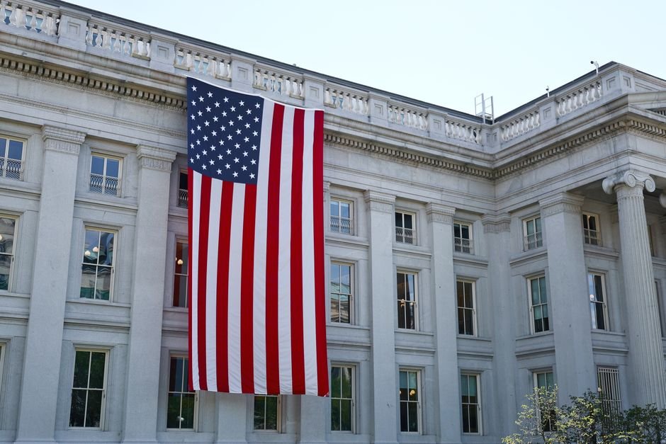 Bandeira dos Estados Unidos pendurada na fachada de prédio oficial com colunas