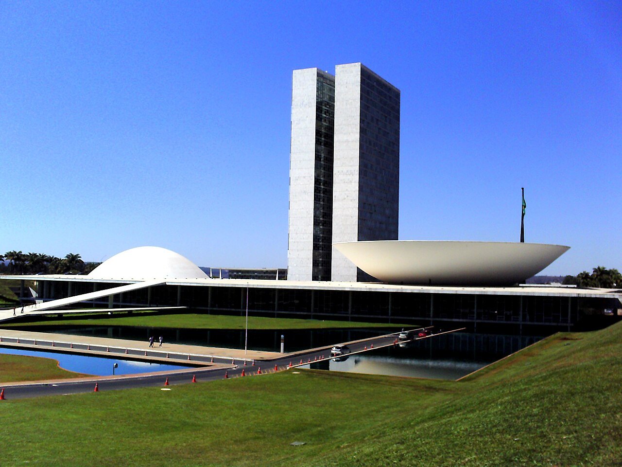 Vista diurna do Congresso Nacional, em Brasília, com as duas torres, a cúpula do Senado e o espelho d'água