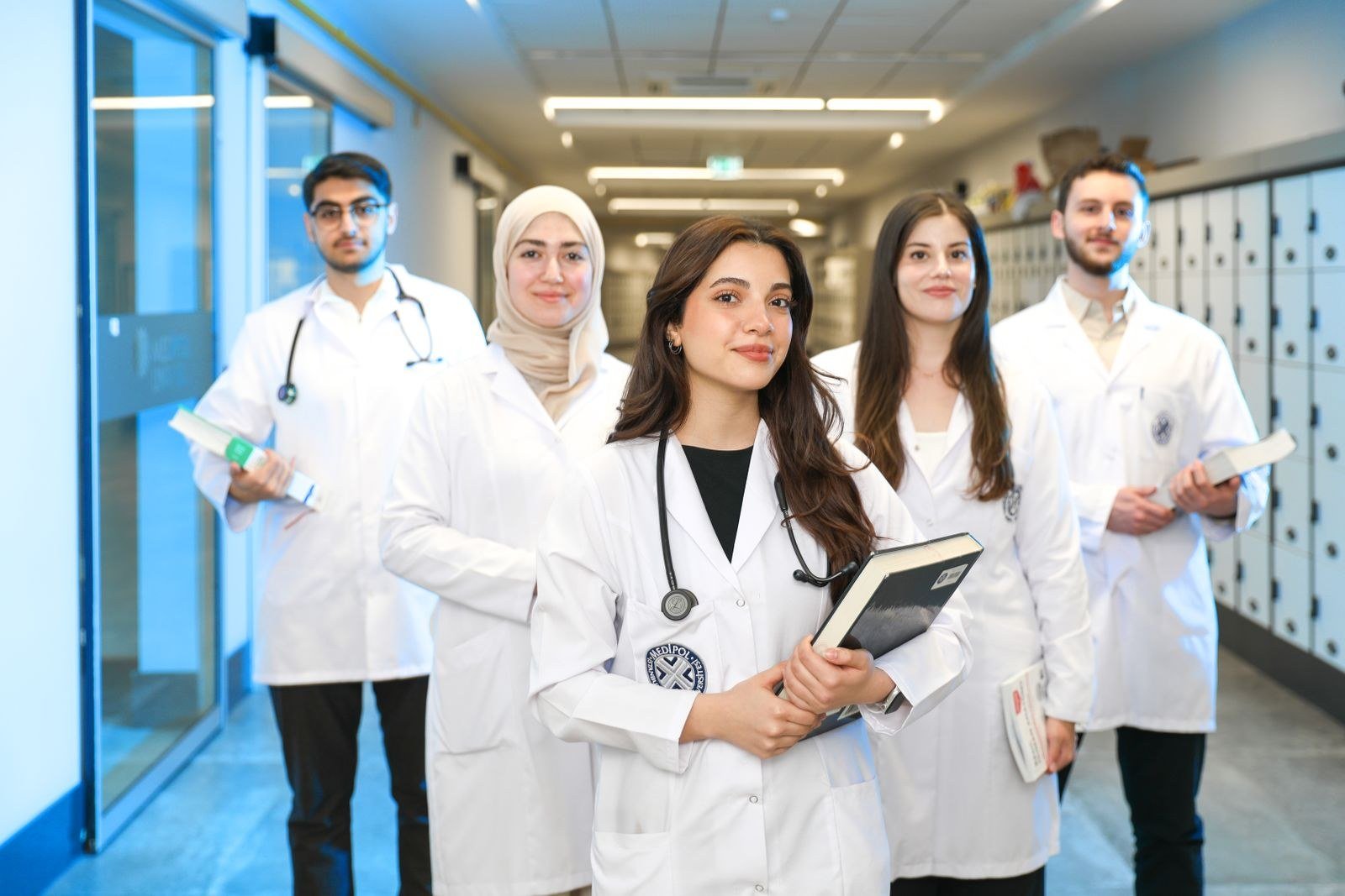 Grupo de estudantes de Medicina de jaleco em corredor de universidade, imagem ilustrativa