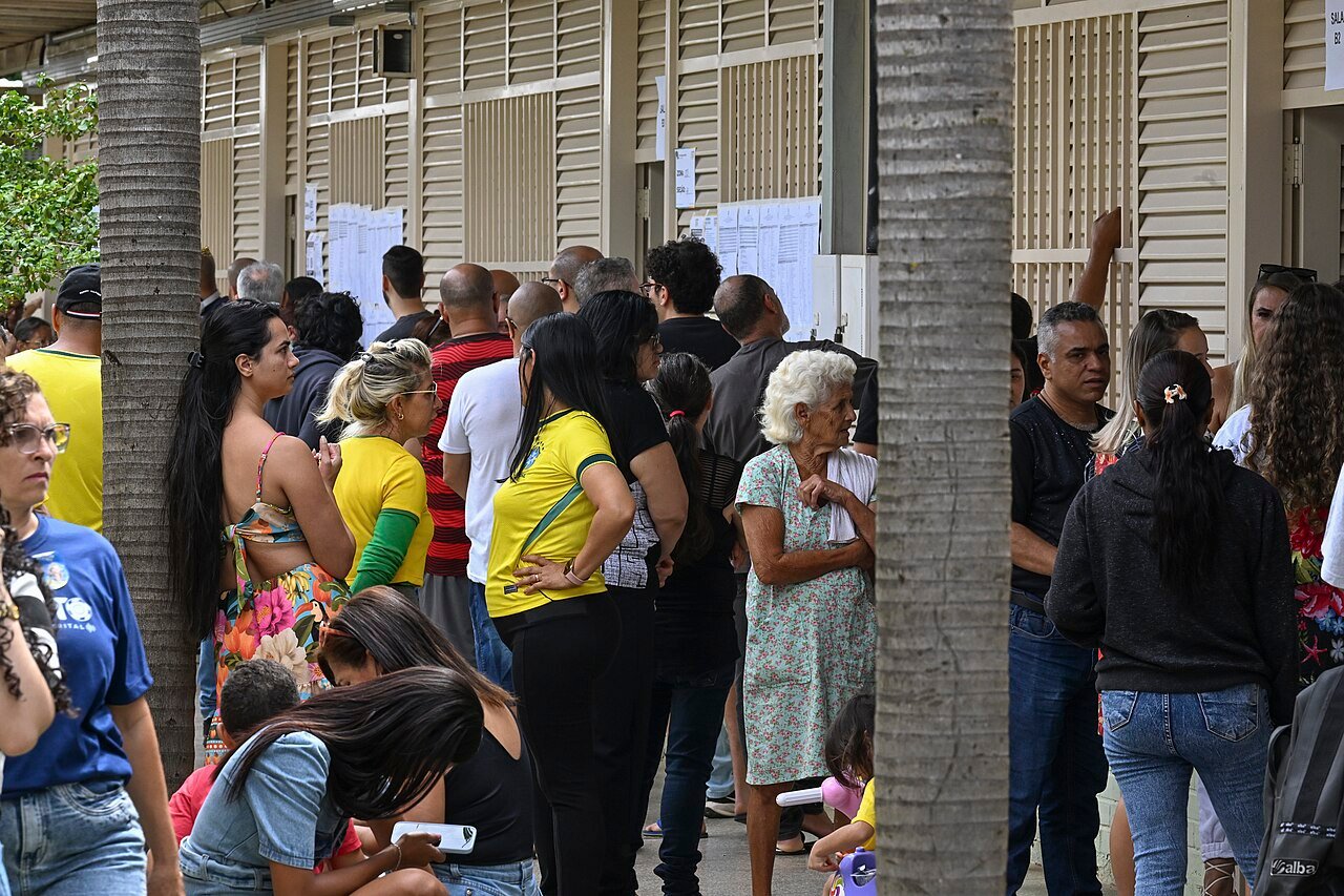 Eleitores aguardam em fila do lado de fora de uma seção eleitoral durante o primeiro turno de 2026