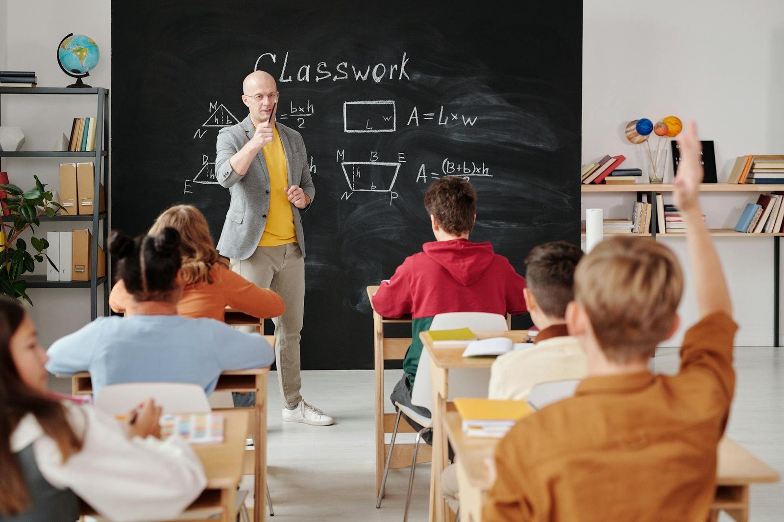 Alunos brasileiros em farda escolar lendo em sala de aula