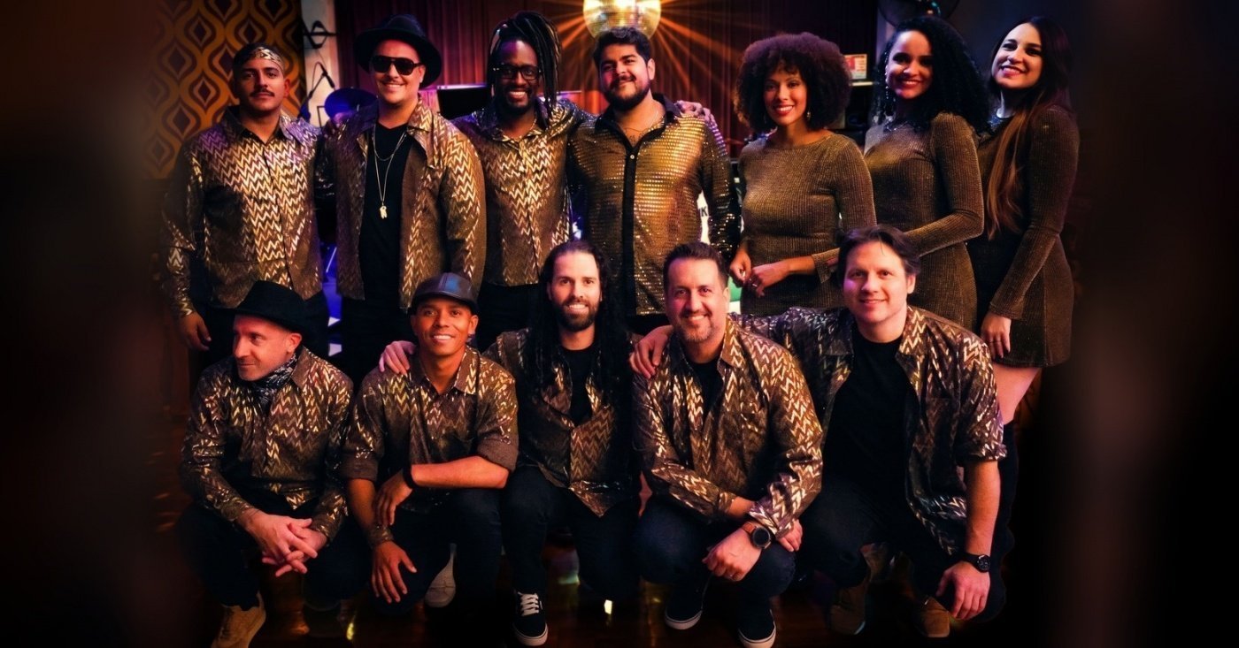 Integrantes da banda Funklosofia posam juntos, com camisas douradas, em foto de divulgação