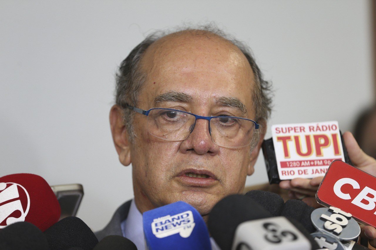 Ministro Gilmar Mendes, do STF, fala a jornalistas cercado por microfones em coletiva de imprensa