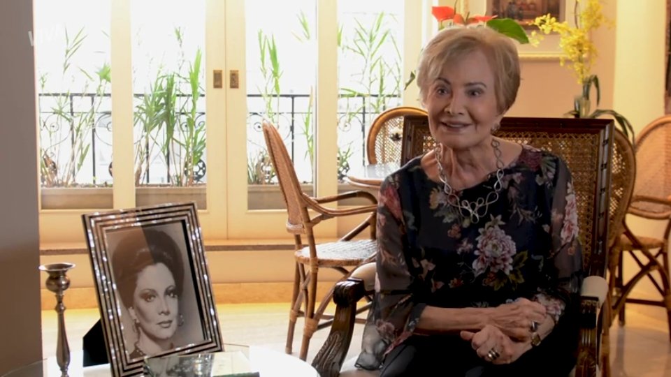 A atriz Glória Menezes em entrevista, sentada em sua casa