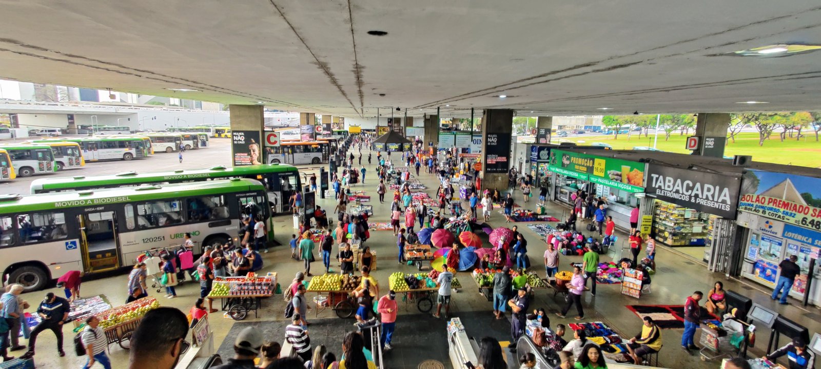 Plataforma da Rodoviária do Plano Piloto cheia de passageiros, com ônibus estacionados ao fundo