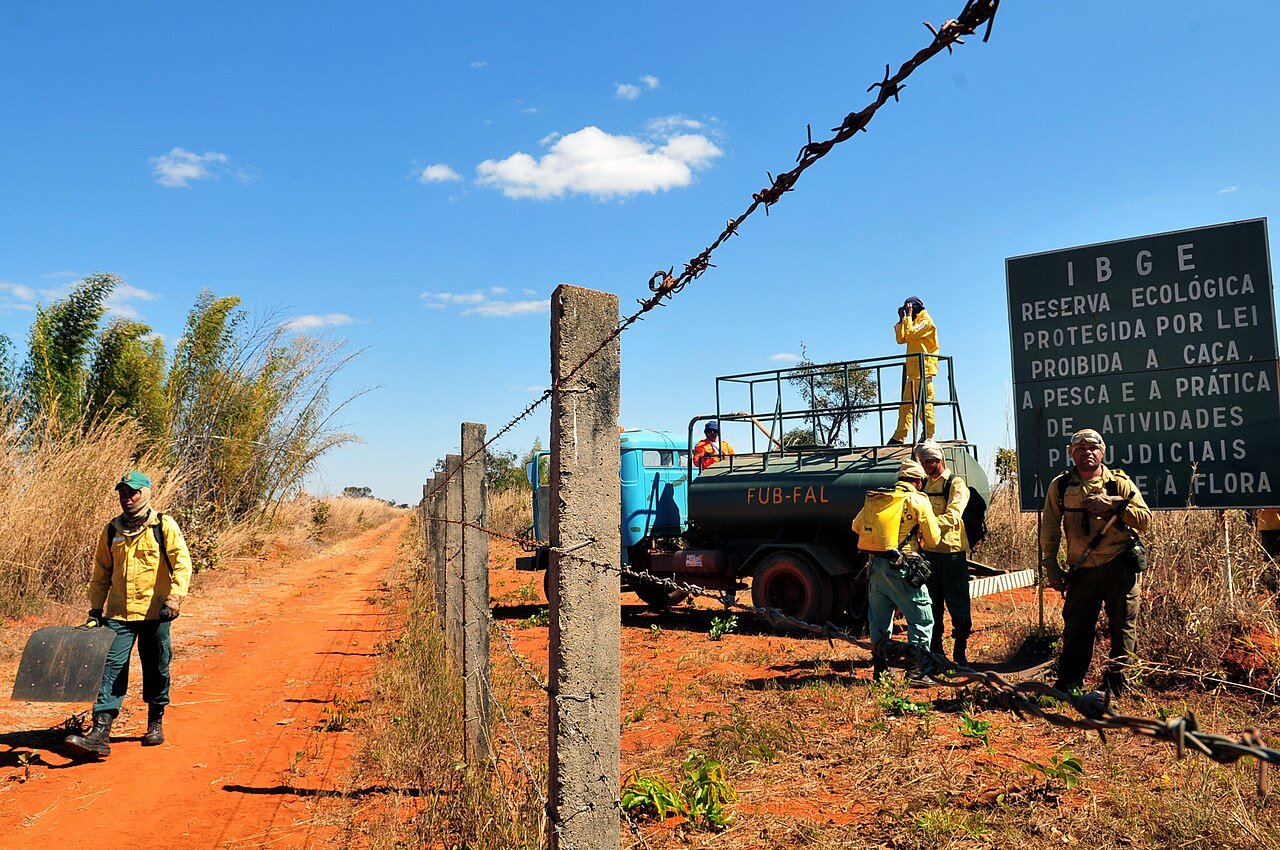 Brigadistas com equipamento de combate a incêndio florestal ao lado de caminhão-pipa em reserva de vegetação no Distrito Federal