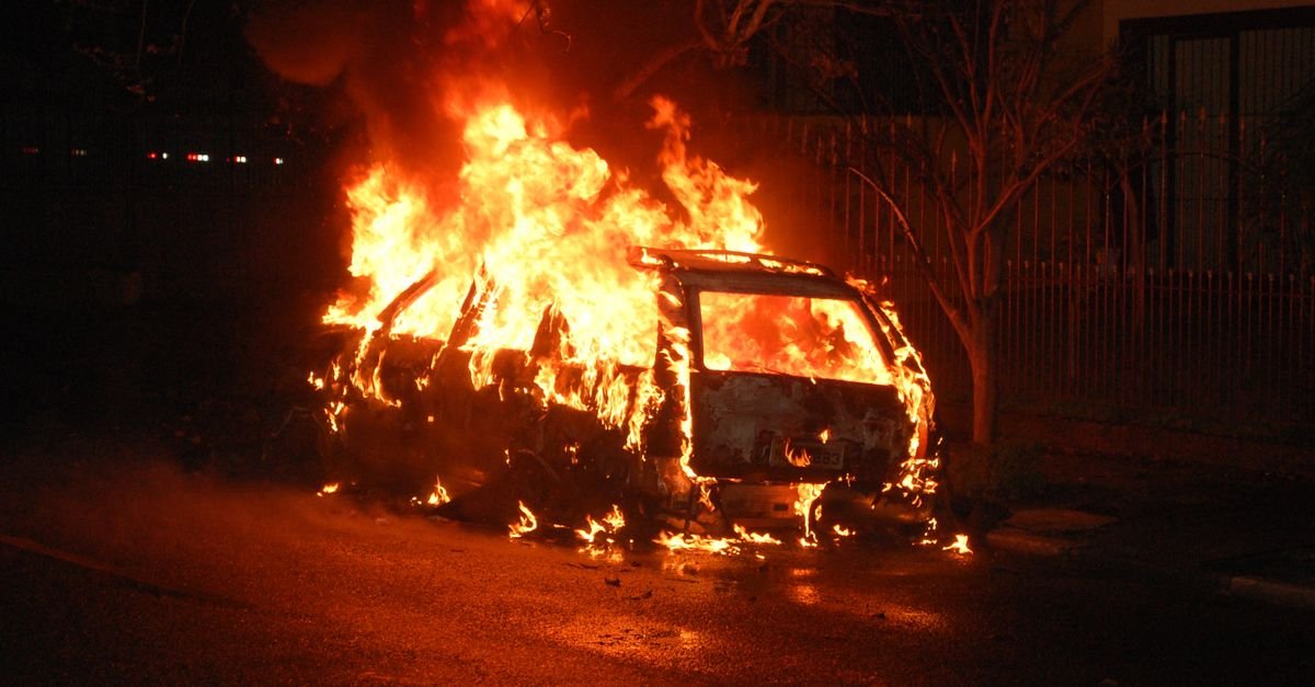 Carro tomado por chamas em via urbana, em imagem que ilustra incêndio veicular