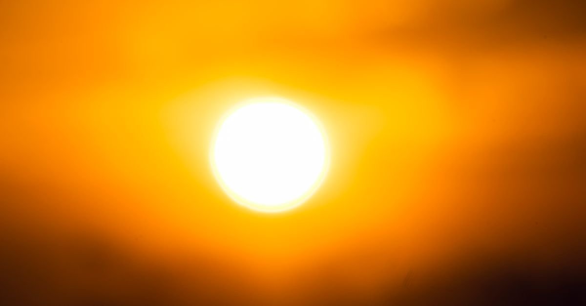 Sol intenso em céu alaranjado durante período de calor e ar seco