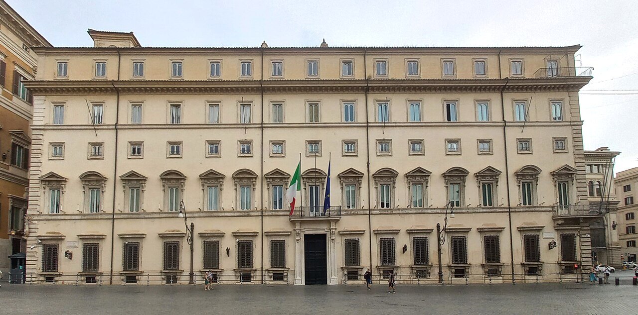 Fachada do Palazzo Chigi, sede do governo italiano em Roma, com as bandeiras da Itália e da União Europeia na varanda central