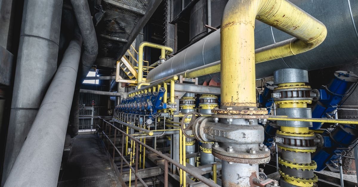 Tubulação industrial com válvulas amarelas e azuis em instalação de armazenamento de combustível