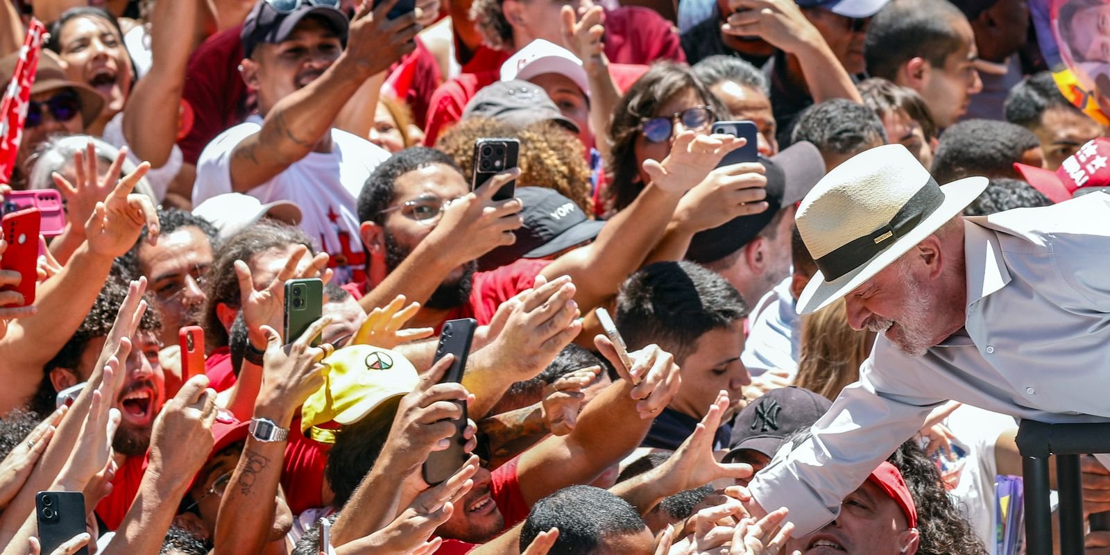 O presidente Lula cumprimenta apoiadores com celulares em punho em ato de campanha na Feira da Ceilândia, em 9 de outubro
